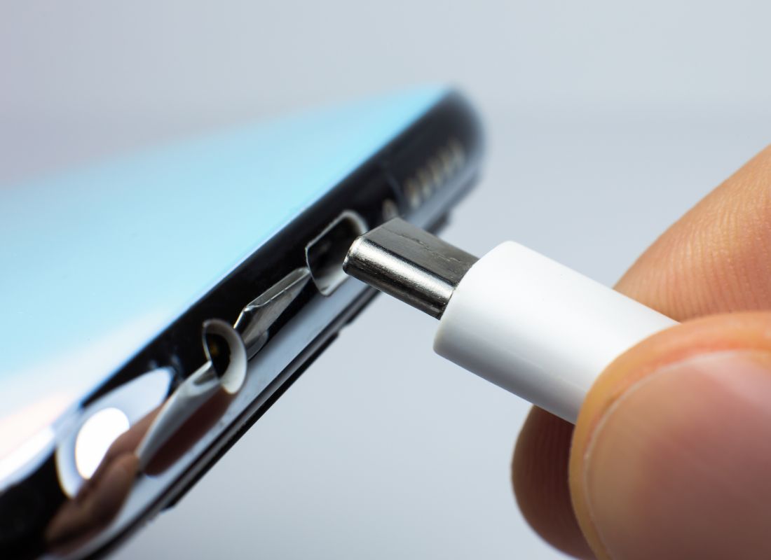 prikaz osobe koja stavlja kabl za punjenje u port telefona